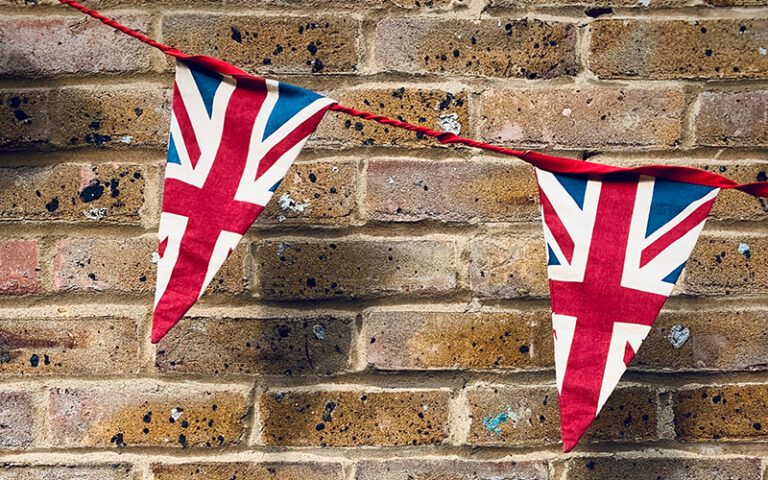 Union Jack bunting against a brick wall