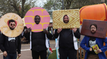 four men wearing cardboard biscuits around their faces